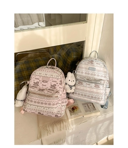 Detail of pink and blue cute backpacks with floral prints and plush rabbit charms