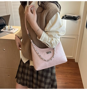 Mannequin portant un sac à bandoulière rose matelassé avec chaîne argentée et fermoir
