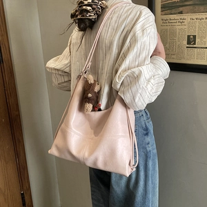 Detail of light pink large hobo tote bag with cute bear charm and stitching accents
