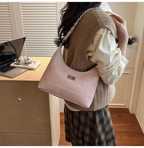 Mannequin portant un sac hobo matelassé rose clair avec bandoulière chaîne argentée
