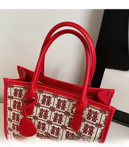 Dettaglio della borsa da sposa rossa con motivo jacquard Xi tradizionale e manici in pelle