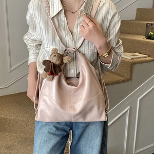 Detail of light pink oversized hobo bag in soft PU leather with brown teddy bear charm