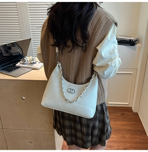 Détail du sac hobo en cuir matelassé blanc avec chaîne argentée et logo métallique