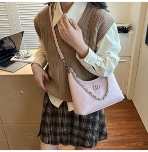 Détail du sac sous l'aisselle en cuir rose matelassé avec chaîne et logo double anneau