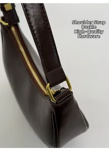 Détails d'un sac en cuir marron brillant avec boucle dorée et coutures de qualité