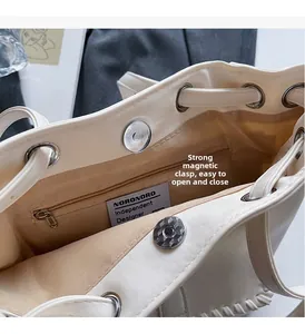 Close-up of minimalist handbag interior featuring magnetic buckle and zipper pocket