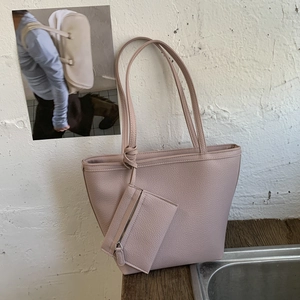 Chic dusty rose pebble leather tote bag with matching coin purse on a wooden surface