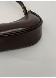 Détail de la base élargie et de la structure renforcée d'un sac demi-lune marron foncé