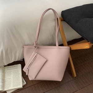Pink lychee texture tote bag set with detachable matching zipper pouch on white cushion