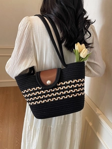 Handwoven black tote bag with striped pattern, brown leather flap and pearl closure
