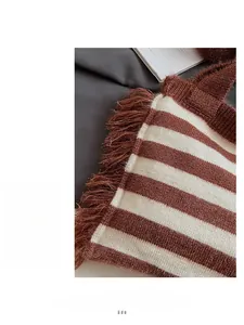 Gros plan du sac cabas en maille rayée marron et beige avec franges fait à la main