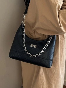 Sac hobo noir matelassé avec chaîne argentée porté avec un trench-coat de couleur kaki