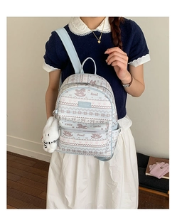 Detail of light blue printed backpack with cute patterns and white rabbit plush charm