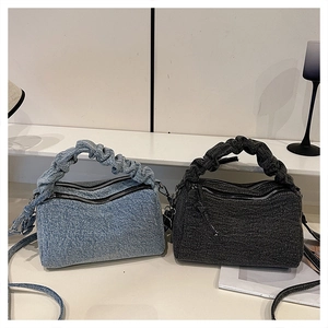 Detail of denim Boston bags with pleated handles in light blue and charcoal grey tones