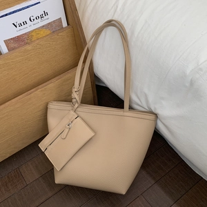 Close-up of beige leather tote bag with lychee texture and matching hanging zipper pouch