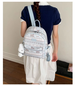 Detail of light blue floral backpack with cute horse prints and plush bunny keychain