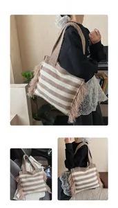 Vue détaillée du sac cabas en maille rayée café et beige avec pompons à franges