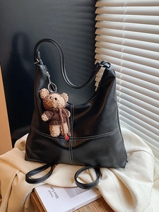 Retro black hobo tote bag with white contrast stitching and a cute bear charm pendant