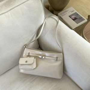 Détail du grand sac porté épaule crème avec boucle en métal et porte-monnaie rond