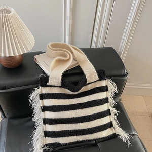 Détail du sac cabas en maille à rayures noires et blanches avec franges latérales