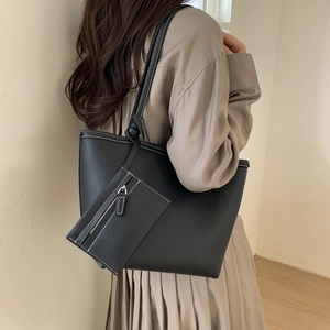 Litchi texture black leather tote bag set with contrast white stitching shown on model