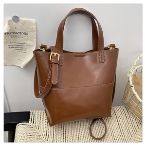 Detail showing smooth brown PU leather texture and adjustable shoulder strap of the tote bag