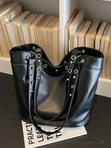 Large black punk tote bag with metallic grommets and rivets for urban commuting style