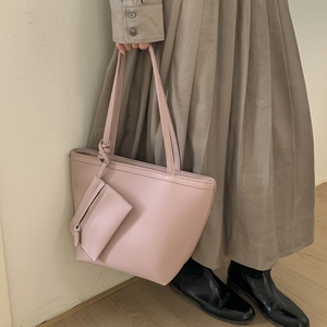 Detail of light pink pebble grain tote bag with slim handles and matching coin pouch accessory