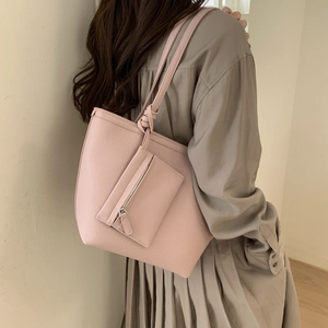 Detail of pink tote bag in lychee leather texture with small zipper pouch accessory