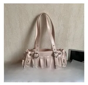 Close-up of pleated beige faux leather tote with silver ring and decorative zipper