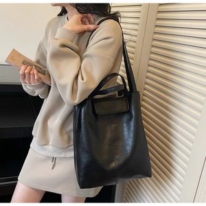 Détail du sac cabas en cuir noir avec lettrage FASHION sur le rabat et bandoulière longue