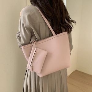 Detail of pink lychee grain faux leather tote bag with matching detachable zip pouch charm