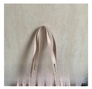 Detail of pink PU tote bag featuring silver metal rings and smooth dual handles