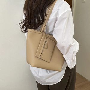 Lifestyle view of khaki tote bag with litchi texture and matching zipper pouch