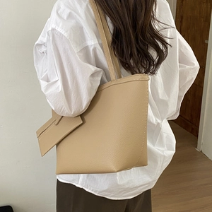 Detail of soft khaki tote bag with litchi texture and matching small pouch