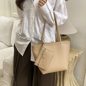 Detail of apricot pebbled leather tote bag with matching interior pouch on hand