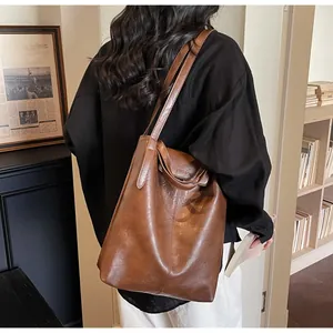 Détail d'un sac cabas vintage en cuir marron avec rabat mode et bandoulière
