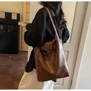 Détail du grand sac cabas marron vintage avec logo fashion embossé sur le rabat avant