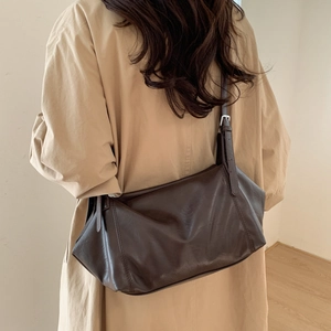 Detail of dark brown leather tote bag with adjustable strap and silver metal hardware