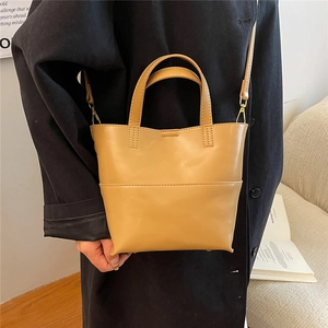 Detail of minimalist ginger PU leather tote bag with adjustable strap and gold metal hooks