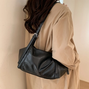 Detail of black pleated shoulder bag showing soft PU leather texture and silver buckle strap