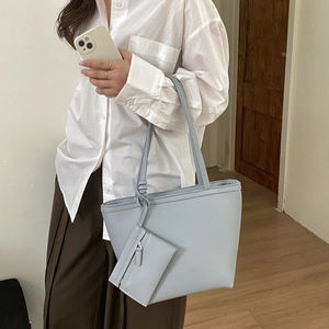 Detail of light blue-grey pebble leather tote bag with a matching small hanging pouch