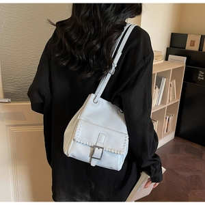 Détail du sac seau bleu clair en similicuir avec coutures blanches et boucle argentée