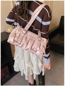 Detailed side view of pink pleated tote bag with glossy finish and silver metal hardware