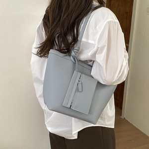 Detail of light blue pebble grain tote bag featuring a matching zipper coin pouch