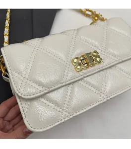 Détail du sac en cuir verni blanc matelassé avec bandoulière chaîne et fermoir doré