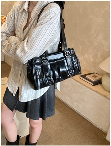 Détail du sac nuage plissé noir avec boucles argentées et cuir verni brillant