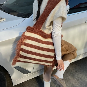 Détail du sac cabas en maille rayée avec franges et texture douce en laine