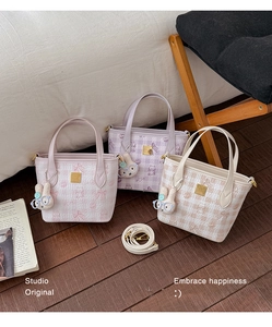 Detail of embossed textured tote bag with cute bunny charm and adjustable strap