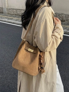 Sac seau vintage en daim marron avec fermoir doré et perles porté en vue extérieure